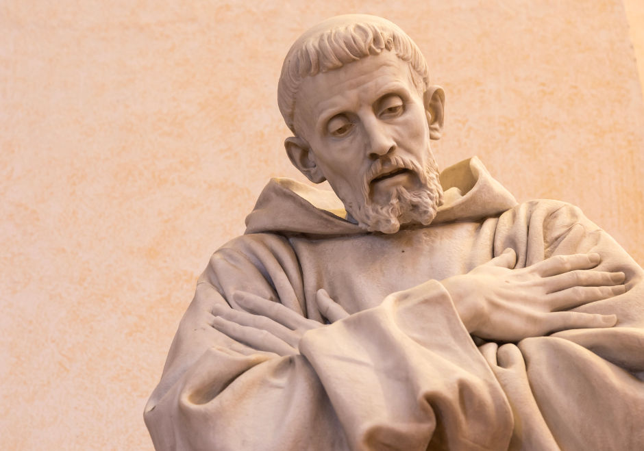 Statua di San Francesco d’Assisi con le mani incrociate sul petto.
